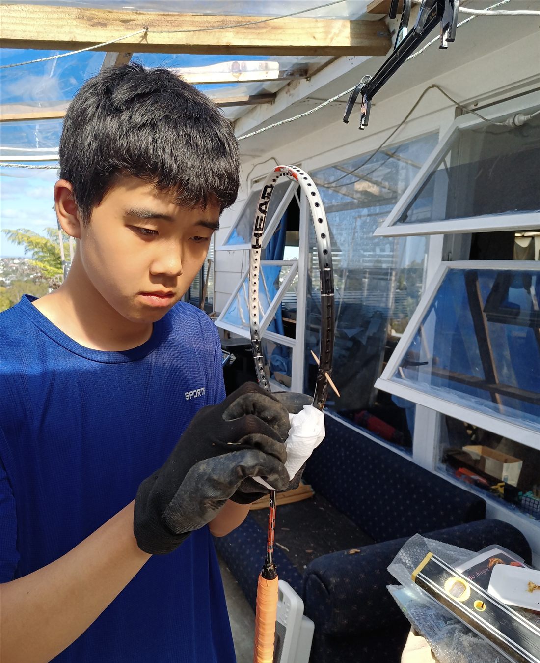 Leo restringing a racquet frame on a stringing machine