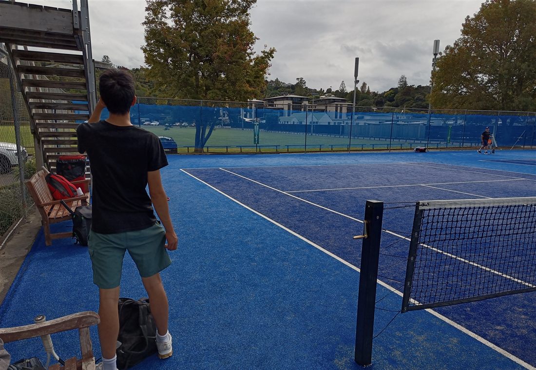 Leo on an outdoor tennis court